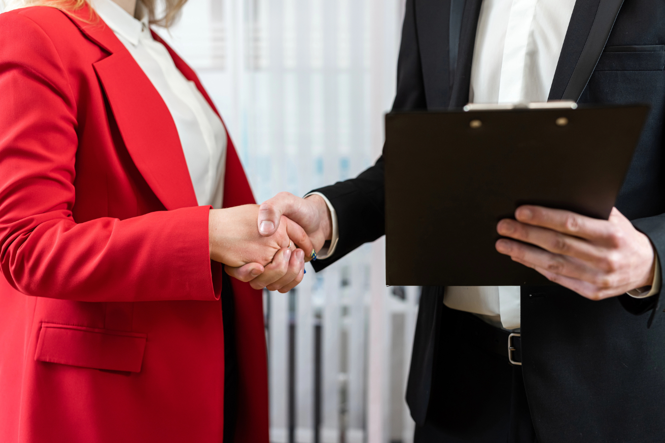 Two business people handshaking after successful partnership in modern office. Successful deal completed